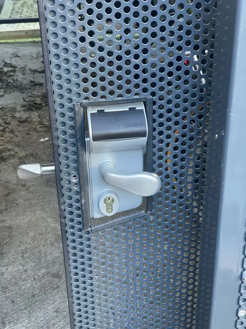 Après : Nouvelle serrure à poignée posée sur la porte grillagée