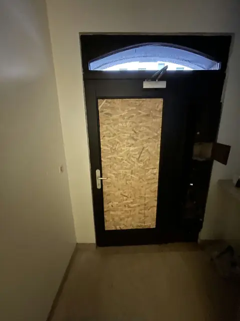 Après : Porte vitrée fermée par un panneau OSB
