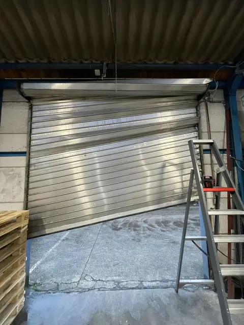 Avant : Ancien volet de garage industriel déformé